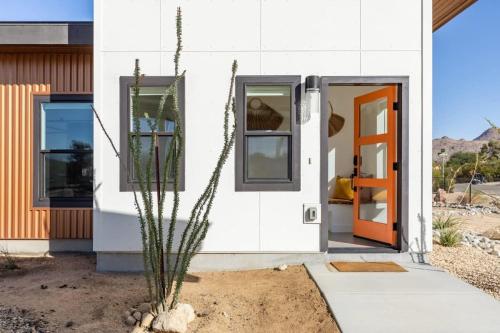 a house with a cactus in the front yard at Desert Contemporary Compound - Large Modern Oasis in Joshua Tree