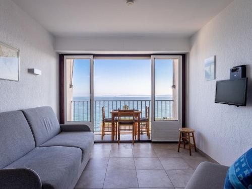 un salon avec un canapé et une table avec vue dans l'établissement Studio Les Horizons-7 by Interhome, au Lavandou