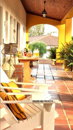a porch with a table and a bench on a patio at Casas do Alpendre in Óbidos