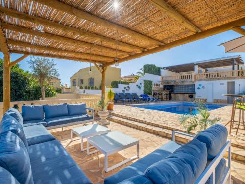 eine Terrasse mit blauen Möbeln und einem Pool in der Unterkunft Villa La Vista by Interhome in Benissa