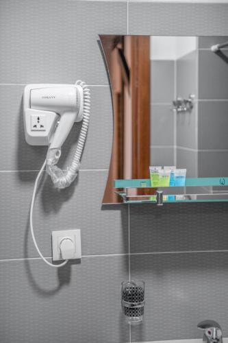 a blow dryer in a bathroom with a mirror at Lotus Hotel in Tbilisi City