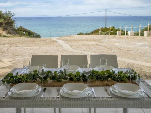 una mesa con platos y copas de vino en la playa en Villa Chicca by Interhome, en Badesi