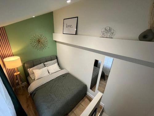 - un petit lit dans une chambre aux murs verts dans l'établissement Une mise au vert en centre ville, à Sens