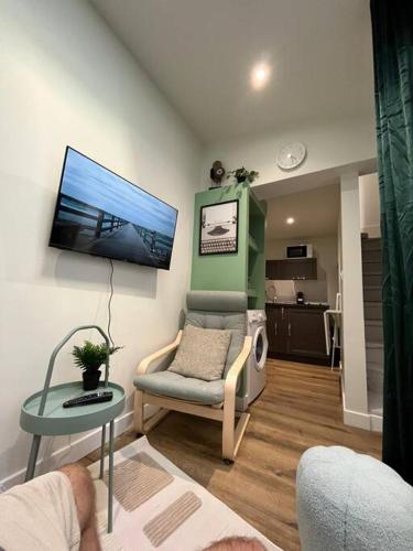 un salon avec une chaise et une table dans l'établissement Une mise au vert en centre ville, à Sens