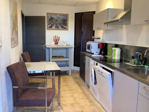 une cuisine avec une table et un comptoir dans l'établissement Apartloisir, à Malaucène