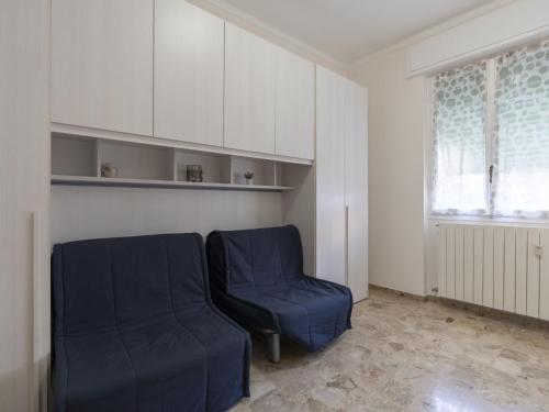 sala de estar con silla azul y ventana en Apartment Alessandro by Interhome, en Diano Marina