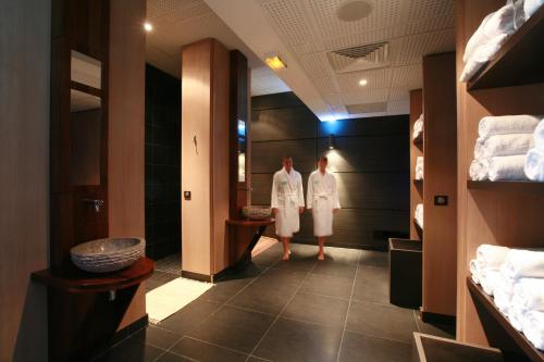 two women in white robes standing in a hallway at Mahogany Hotel Residence & Spa in Le Gosier