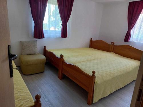- une chambre avec un lit et une chaise dans l'établissement Apartman Tošić, à Trnava