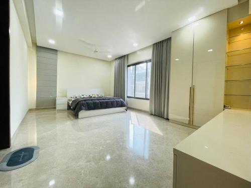 a bedroom with a bed and a large window at Ultra stylish 3bhk & home theatre room in Hyderabad