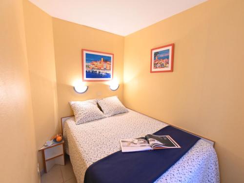 Cette petite chambre comprend un lit et un livre. dans l'établissement Apartment Le Village - C4221 by Interhome, à Agay
