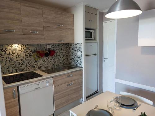 une cuisine avec des armoires en bois et un comptoir dans l'établissement Apartment Le Belvédère - R1 110 by Interhome, à Agay