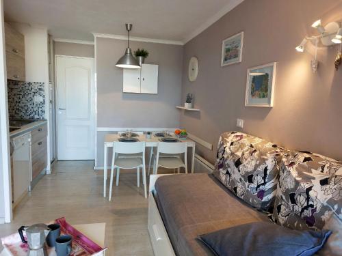 un salon et une cuisine avec un canapé et une table dans l'établissement Apartment Le Belvédère - R1 110 by Interhome, à Agay