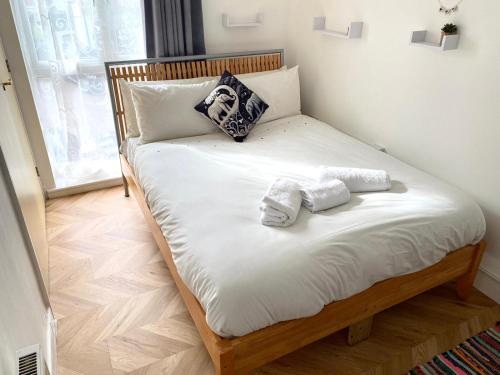 Una cama con dos toallas encima. en Norwich Apartment - Cosy & Comfortable 1 Bedroom en Goodmayes