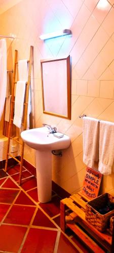 a bathroom with a sink and a mirror and towels at Casas do Alpendre in Óbidos