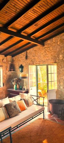 a room with a bed in a stone wall at Casas do Alpendre in Óbidos