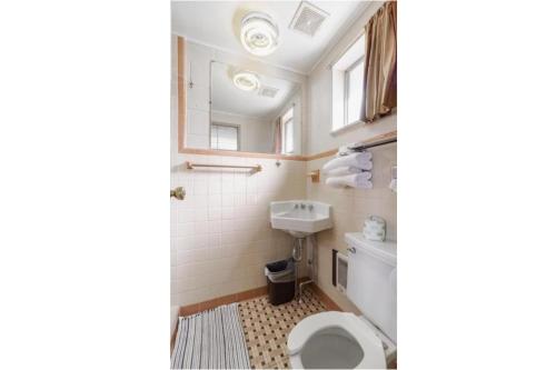 y baño con aseo y lavamanos. en DuBois Manor Motel by OYO, en DuBois