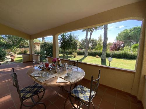 una mesa y sillas en un porche con una gran ventana en Holiday Home Siby-3 by Interhome, en Casale Marittimo