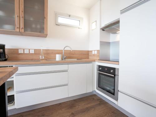 une cuisine avec des armoires blanches et un évier dans l'établissement Apartment le Galion-3 by Interhome, à Arcachon