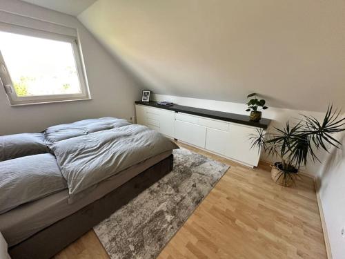 a white bedroom with a bed and a window at Sonniges & ruhiges Apartment mit Balkon nahe Berlin in Zeuthen