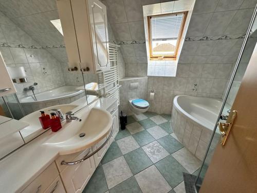 a bathroom with a sink and a tub and a toilet at Sonniges & ruhiges Apartment mit Balkon nahe Berlin in Zeuthen
