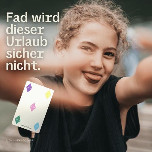 a woman holding a playing card in front of her face at Pension Arkadenhof in Loipersdorf bei Fürstenfeld
