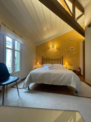 a bedroom with a large bed and a blue chair at Pension Isabo in Nafplio
