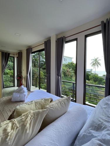 a bedroom with two beds and large windows at SEASUN Villa Haad Tien in Haad Tian