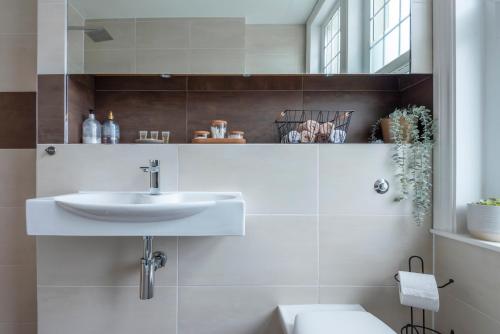 a bathroom with a sink and a toilet at Woodside Gardens Luxury Properties near Alexandra Palace, Tottenham Stadium & Drumsheds in London
