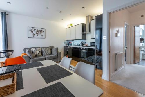 a kitchen and living room with a table and chairs at Woodside Gardens Luxury Properties near Alexandra Palace, Tottenham Stadium & Drumsheds in London