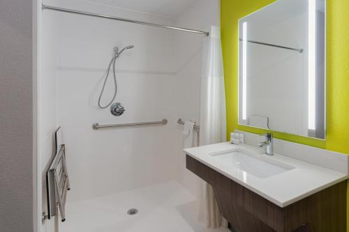 uma casa de banho com um lavatório e um espelho em La Quinta by Wyndham Shawnee em Shawnee