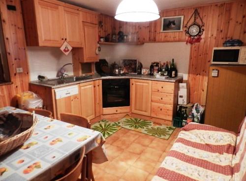 a kitchen with wooden cabinets and a table in it at PM 10 Via Don Aldo Osquez Guest House in Antey-Saint-André
