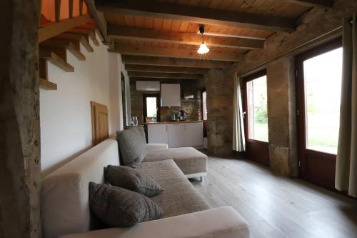 ein Wohnzimmer mit einem Sofa und 2 Stühlen in der Unterkunft Petit Gîte chez Domaine Château de Bussolles in Barrais-Bussolles