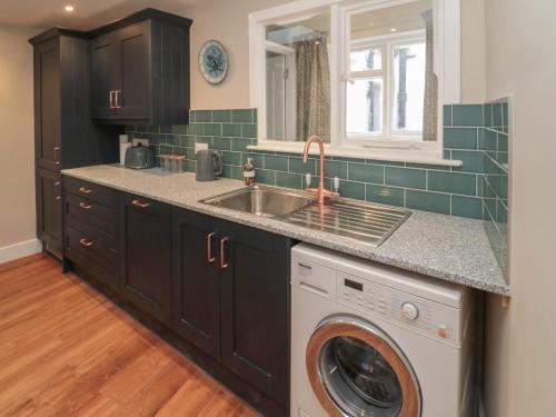 a kitchen with a sink and a washing machine at Salmon Cottage in Berwick-Upon-Tweed