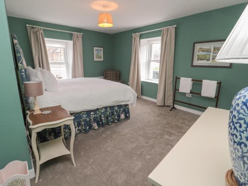 1 dormitorio con 1 cama grande y paredes verdes en Salmon Cottage, en Berwick-Upon-Tweed