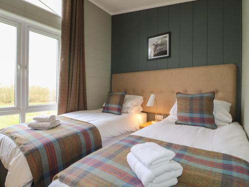 a bedroom with two beds and a window at Cedar Lodge in Newark-on-Trent