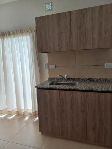 a kitchen counter with a sink and a window at La Juana in Almafuerte