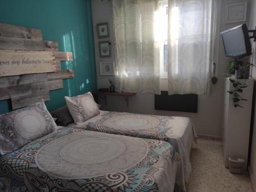 ein Schlafzimmer mit 2 Betten und einem TV in der Unterkunft habitación doble con aseo compartido in Coria del Río