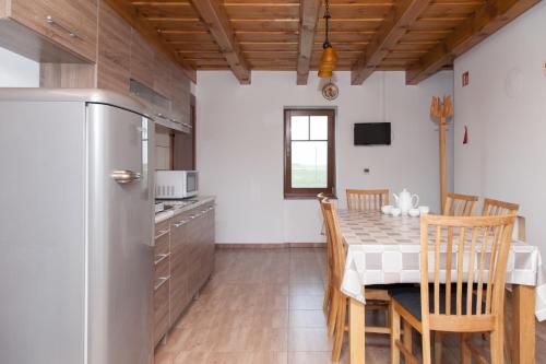 a kitchen and dining room with a table and chairs at Csodaszarvas Vendégházak in Rábahidvég
