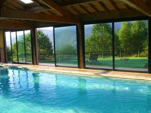 a swimming pool with a view of the mountains at Auberge Les Myrtilles in Le Bosc