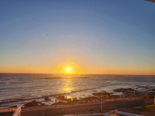 a sunset over the ocean with the sun setting at The Blue Peter Hotel in Cape Town