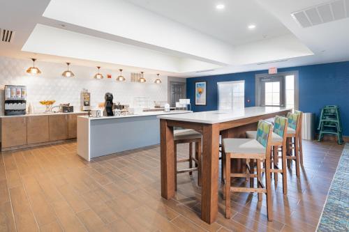 a kitchen with blue walls and a table and chairs at La Quinta by Wyndham Shawnee in Shawnee