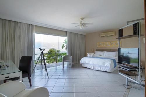 a hotel room with a bed and a television at Hotel Itapemar - Ilhabela in Ilhabela