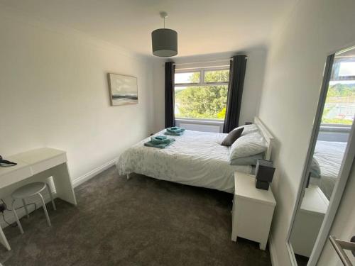een slaapkamer met een bed, een bureau en een raam bij Place to stay overlooking Falmouth marina in Flushing