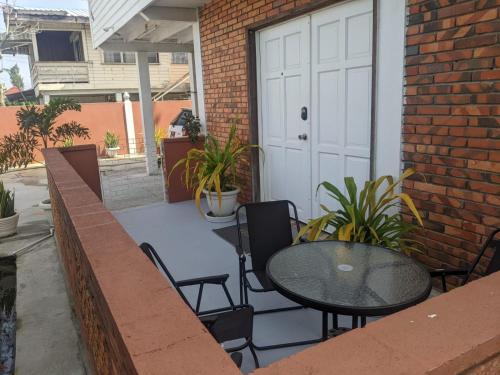 a patio with a table and chairs and a white door at Destination Hope in Georgetown