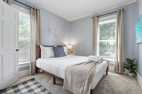 a bedroom with a bed and two windows at The Indiana Stunner in Columbus