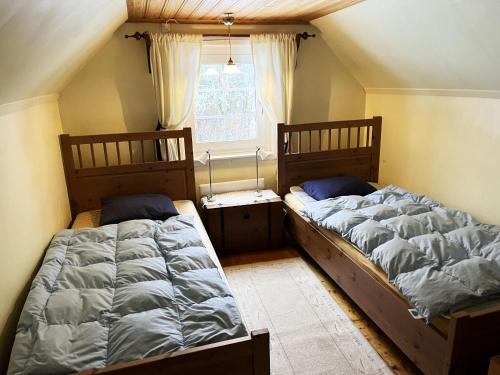 Кровать или кровати в номере Small red cottage located close to forest outside Virserum