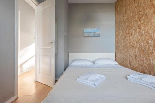 um quarto com uma cama com duas toalhas brancas em 't Schelpje with free parking em Zandvoort