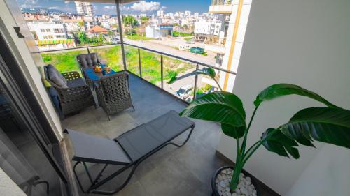 a balcony with a table and chairs and a plant at Stile Suite Marine Hotel in Antalya