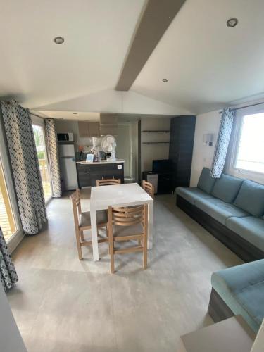 un salon avec une table et un canapé dans l'établissement mobil home 394 - Domaine de Kerlann, à Pont-Aven