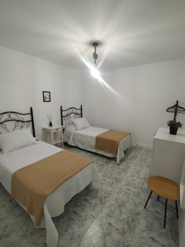 a bedroom with two beds and a cross on the wall at Caballito de mar in Malpica